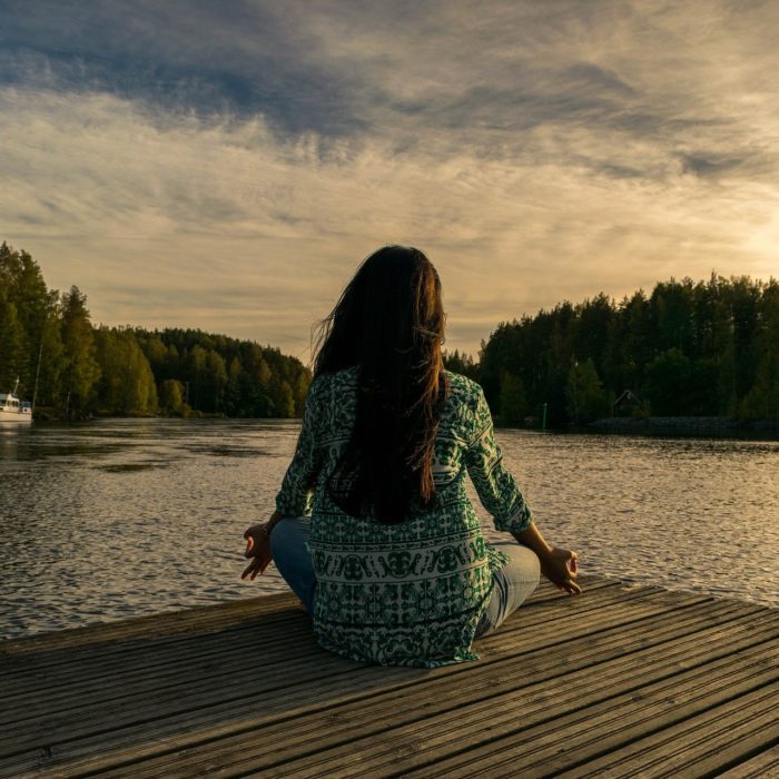 woman meditating on a dock