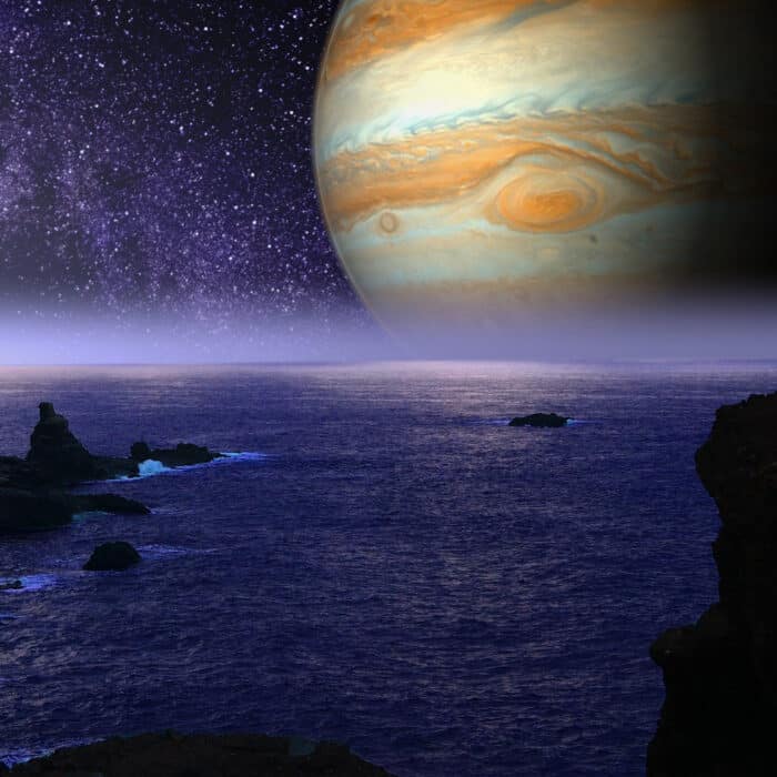 Rocky sea showing the planet Jupiter on the starry sky background