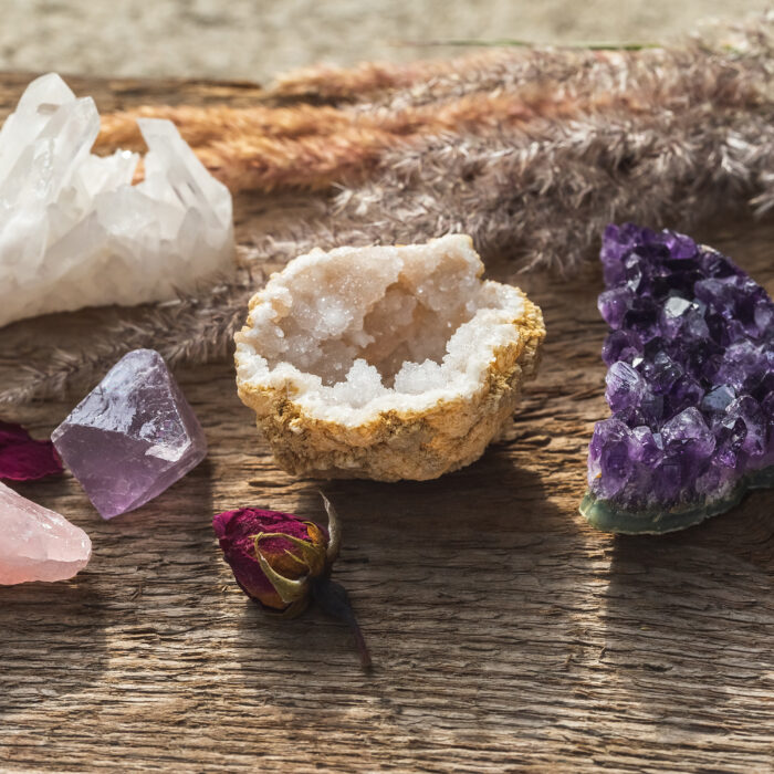 Multiple Gemstones for Esoteric Spiritual Practice or Witchcraft Set Up on Wooden Table with Dry Herbs and Flowers. Stones and Minerals Collection.