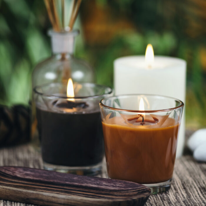 Scented brown candles. Pine cone and essential oil diffusers in background