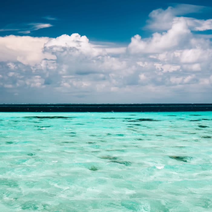 cloudy blue sky above a clear ocean water