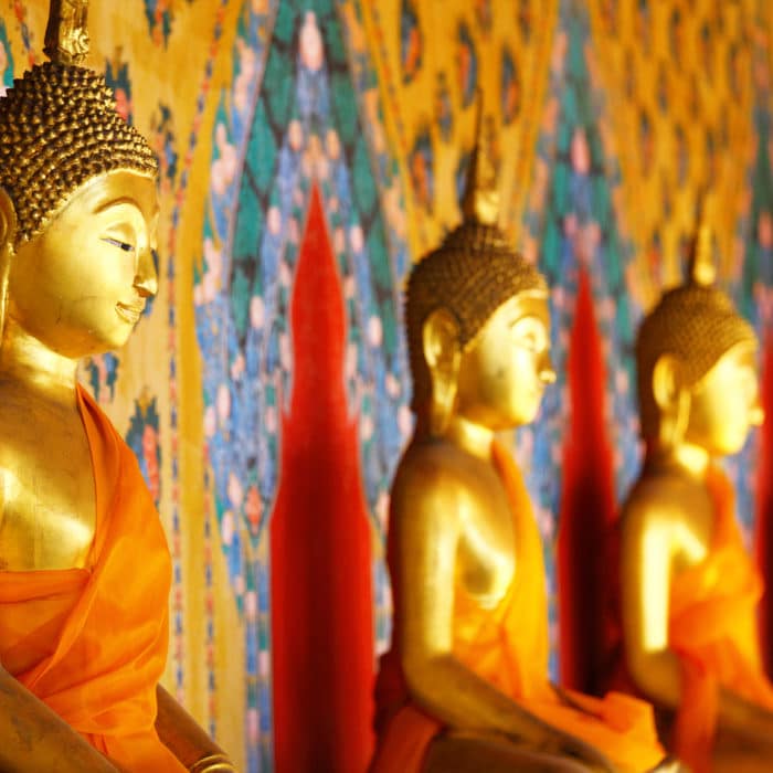 golden buddha statues lined up in the temple