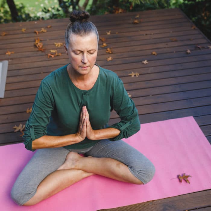 Woman practicing yoga Pink Tourmaline Meditation and Grounding