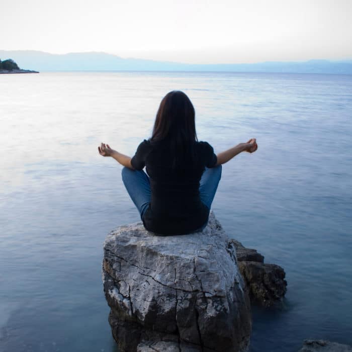 Woman meditating by the sea Amblygonite Meditation and Grounding