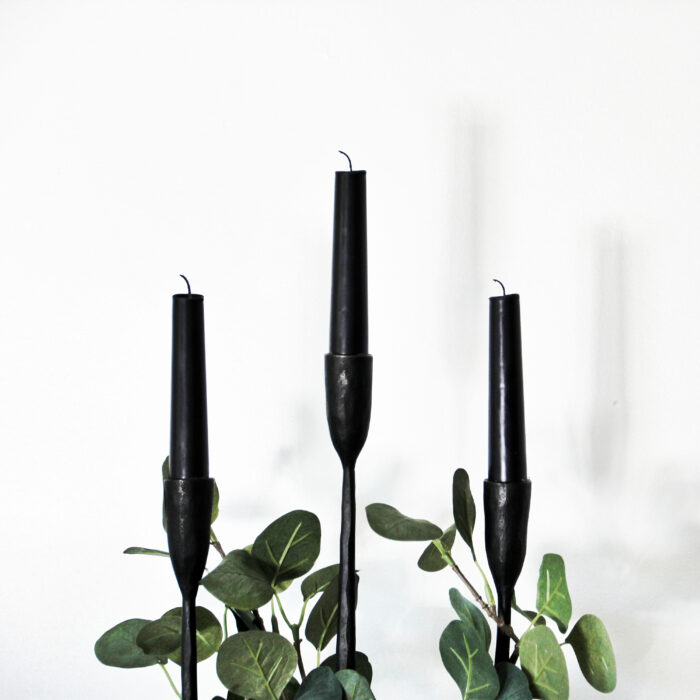 Three candles with plant leaves