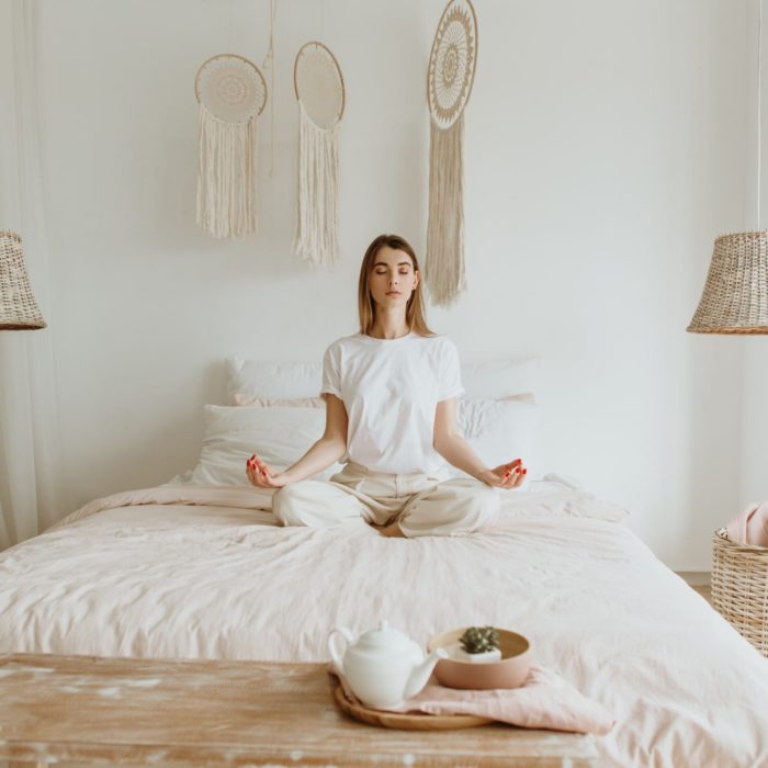 woman doing meditation on the bedroom