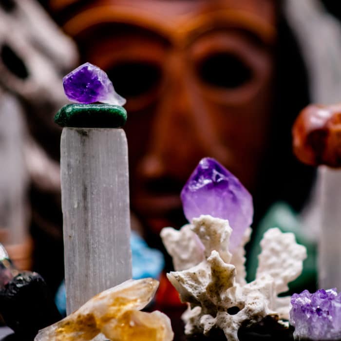 various crystals with a tiki statue on the background