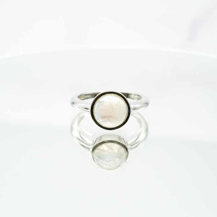 Circular ring made of rainbow moonstone on a white surface