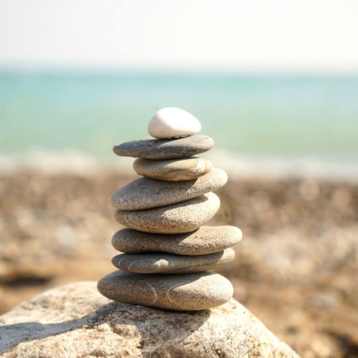 pile of stones on top of each other balancing on a rock in the seashore
