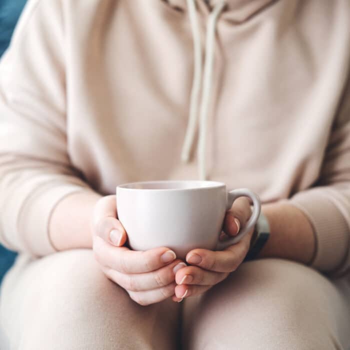 Self care, staying home, cozy mood. Take care of yourself, Love yourself concept. Woman hands with cup of hot drink at home.