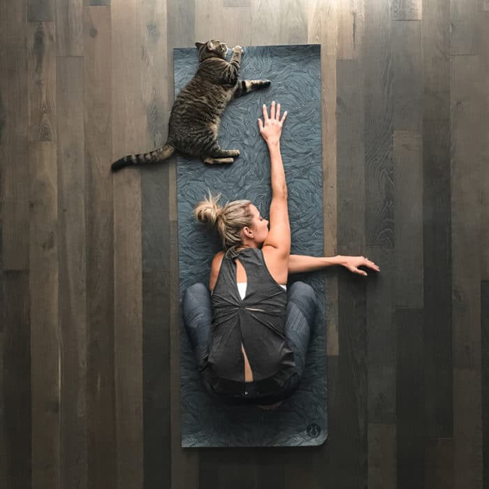 woman and cat practicing yoga