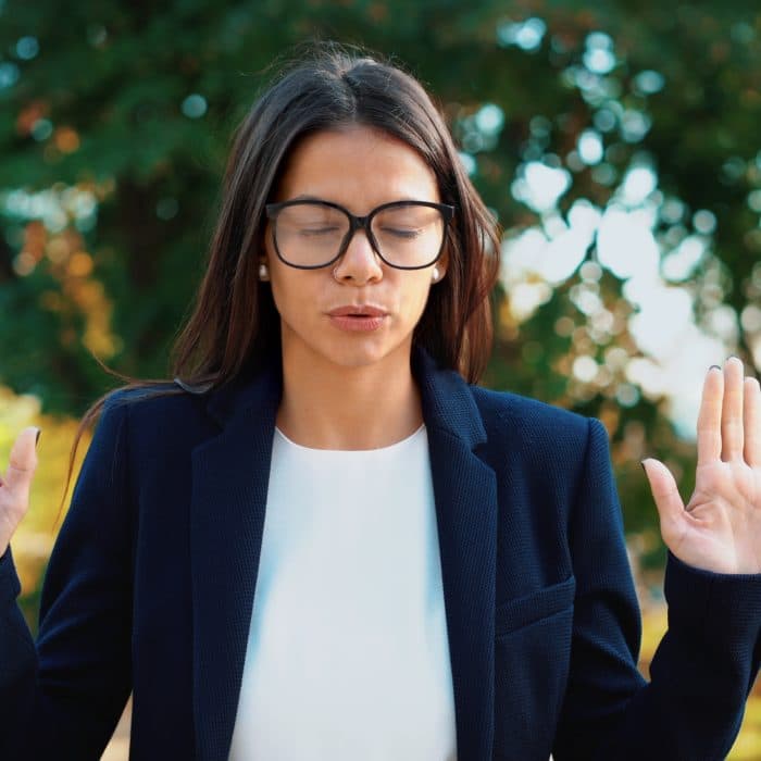 young woman wearing business suit doing meditation