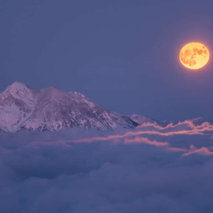 Full moon rising over the clouds