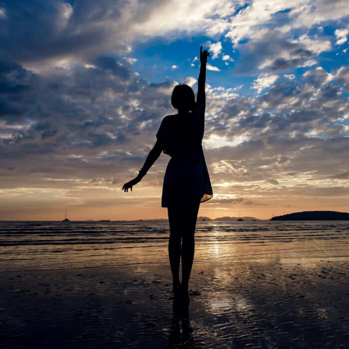 Happy Carefree Woman Enjoying Beautiful Sunset on the Beach. famous Ao Nang beach in Krabi province, Thailand