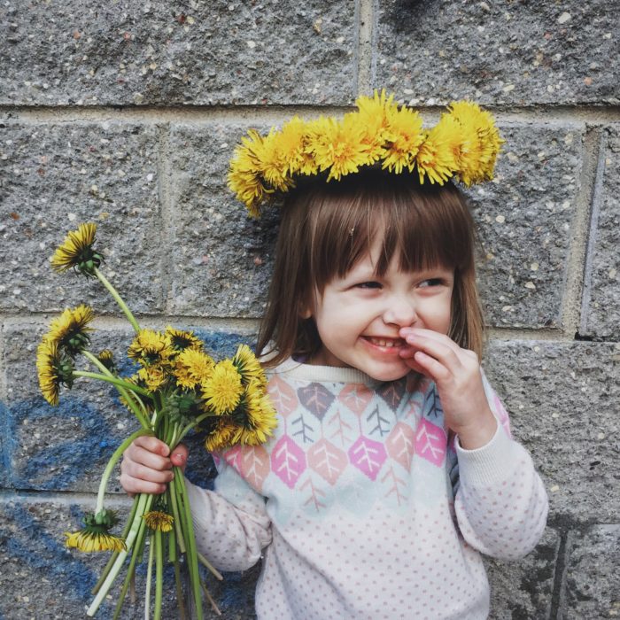 happy kid holding yellow flowers