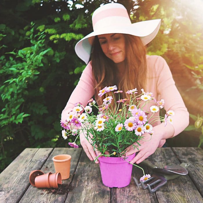 woman wearing hat arranging flowers