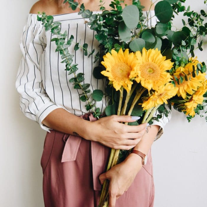 woman holding bouquet of yellows flowers