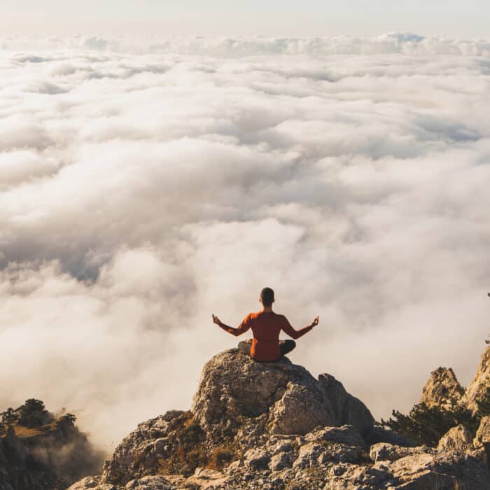 Woman meditating atop the mountain