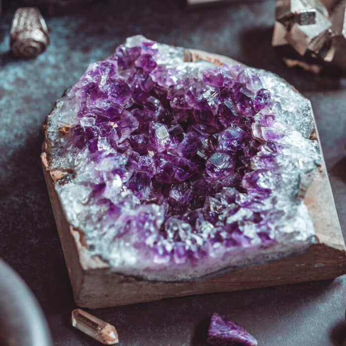 Amethyst Druze on a witch's altar for a magical ceremony among crystals and black candles.