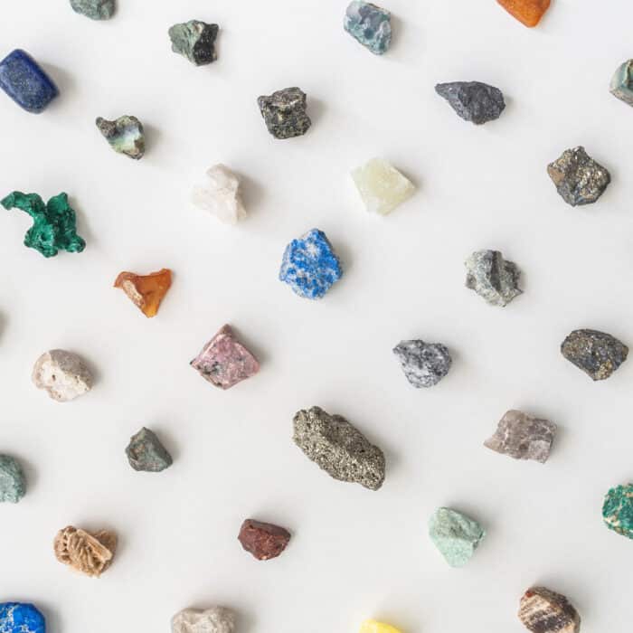 Collection of natural stones and minerals. Colorful various uncut and raw mineral stones, gemstone and healing stone collection of various colors and shapes on white background. Top view