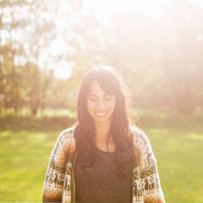 Happy young woman with eyes closed at field