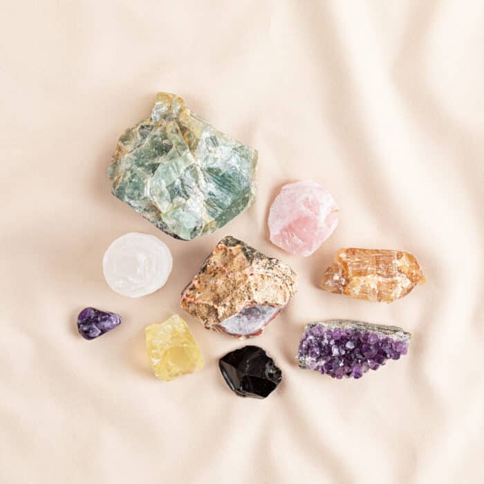 Healing reiki chakra crystals over fabric background. Gemstones for wellbeing, harmony, meditation, relaxation, metaphysical, spiritual practices. Energetical power concept