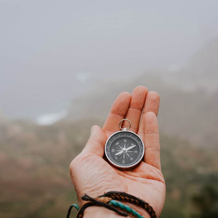 Looking at the compass to figure out right direction. Foggy valley and mountains in background. Santo Antao. Cape Cabo Verde and mountains in background. Santo Antao. Cape Cabo Verde.