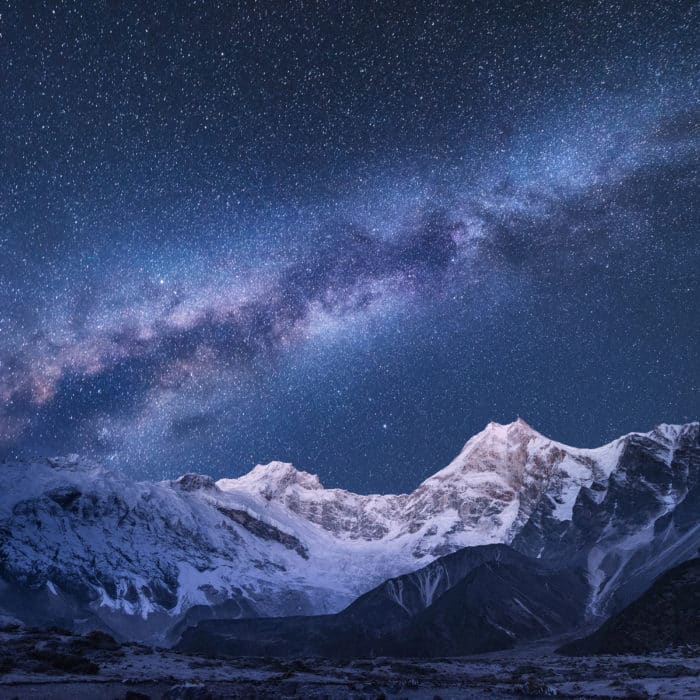 Milky Way and mountains. Amazing scene with himalayan mountains and starry sky at night in Nepal. Rocks with snowy peak and sky with stars. Beautiful Himalayas. Night landscape with bright milky way
