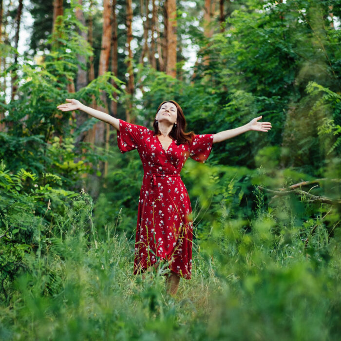 Connecting with nature benefits mental health. Nature Therapy Ecotherapy Helps Mental Health. Nature Impact Wellbeing. Woman in red dress enjoying nature.