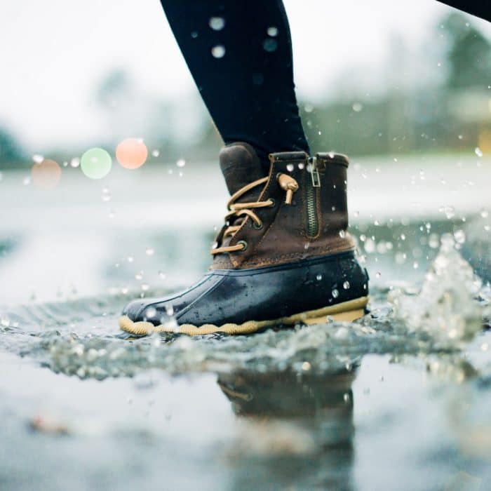 close up on shoes splashing on water