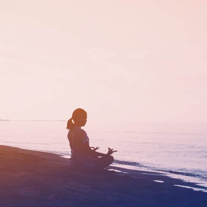 Woman meditating near the sea