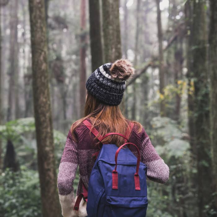 Young woman traveler walking in the forest