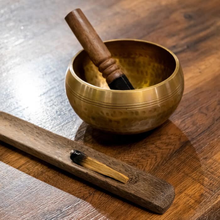 Meditation with Tibetan singing bowl and burning aroma stick on wooden background