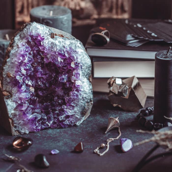 Amethyst Druze on a witch's altar for a magical ritual among crystals and black candles.