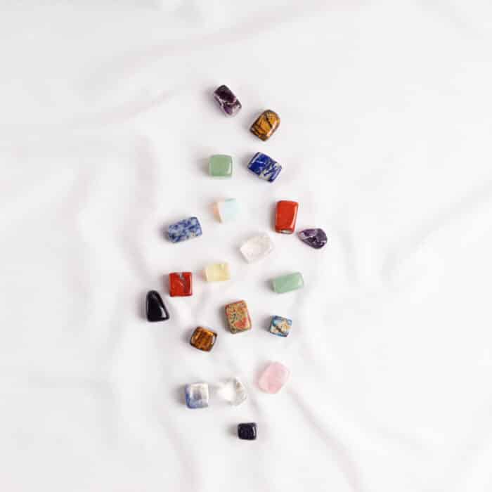 Healing reiki chakra crystals over white fabric background. Gemstones for wellbeing, harmony, meditation, relaxation, metaphysical, spiritual practices. Energetical power concept