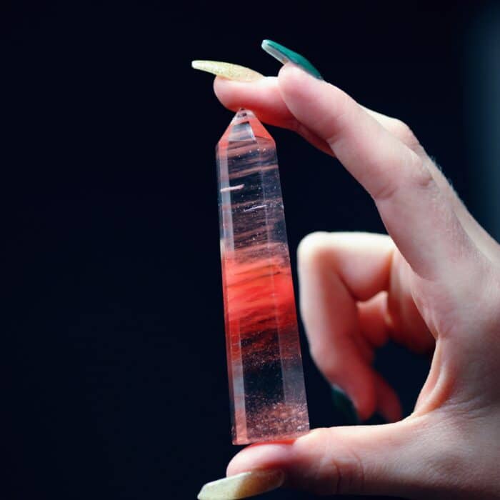 Person holding a red crystal with black accent colors