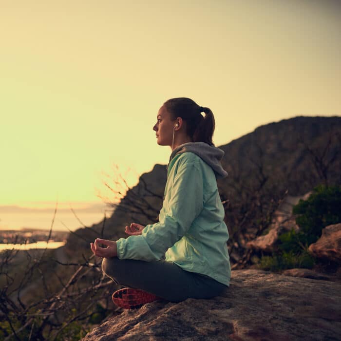 Meditation with a view. Full length shot of a sporty young woman meditating outdoors
