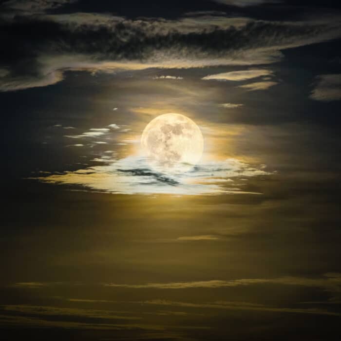 Super full moon on the yellow sky at midnight, golden moonlight reflect the cloud, Beautiful nature landscape view at night scene for background