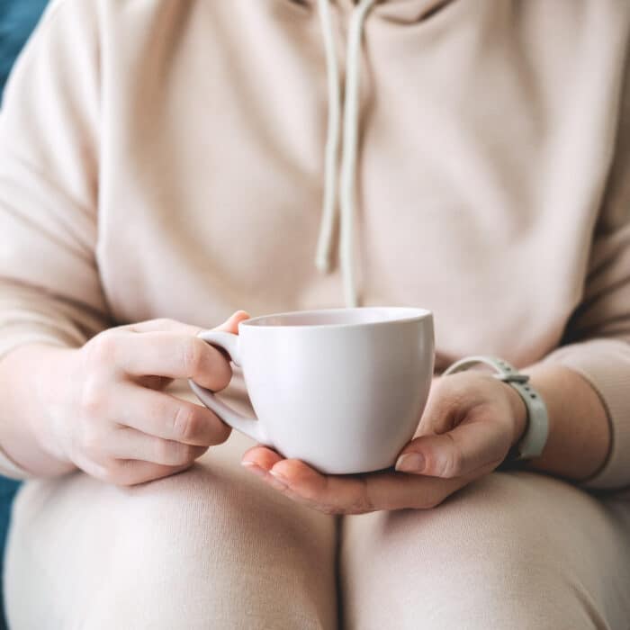 Self care, staying home, cozy mood. Take care of yourself, Love yourself concept. Woman hands with cup of hot drink at home.