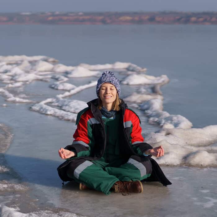 Woman meditating in a wintry icy sea