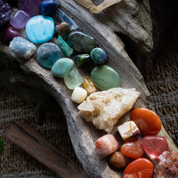 Chakra river of gemstones on driftwood