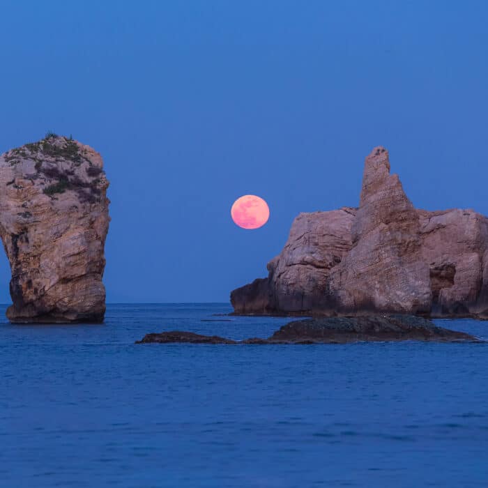 Full moon rising over the sea rocks