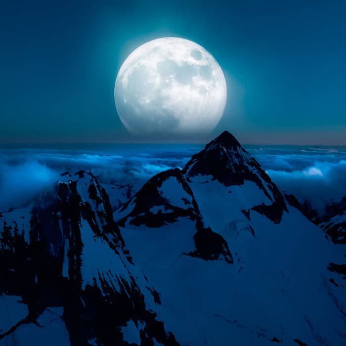 Magical Artistic Scene of Canadian Rocky Mountains with Full Moon Glowing in the background. Aerial View from an Airplane of Landscape near Squamish, British Columbia, Canada.