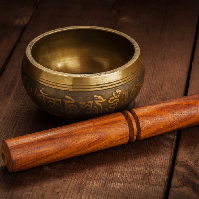 Tibetan buddhist singing bowl, rin gong, Himalayan bowl or suzu gong for meditation, music, relaxation, and personal well-being with mallet on wooden background