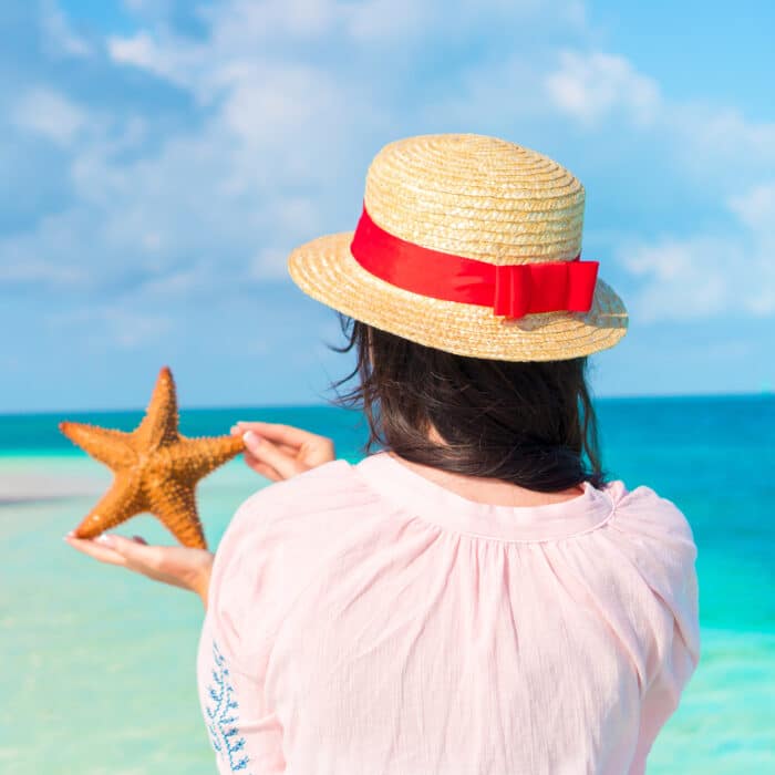 Adorable girl with starfish on the beach