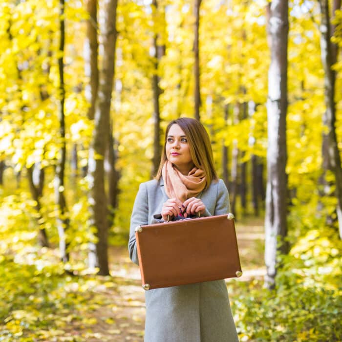 Autumn, nature and people concept - Young beautiful woman in grey coat in fall nature.
