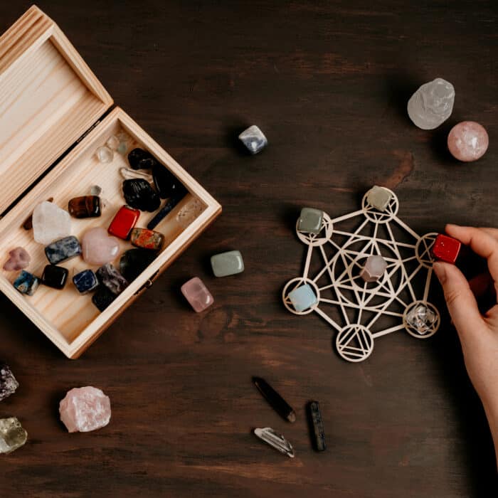 Woman making healing chakra chystal grid. Rituals with gemstones and aromatherapy for wellness, healing, meditation, destress, relaxation, mental health, spiritual practices. Energetical power concept