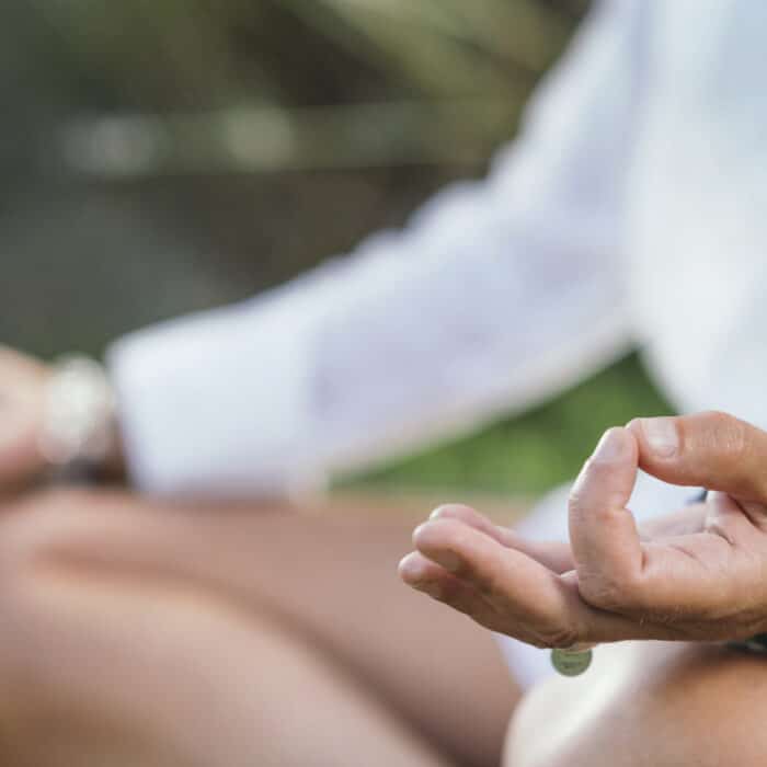 Woman meditating, balancing energy. Hands in mudra position.
