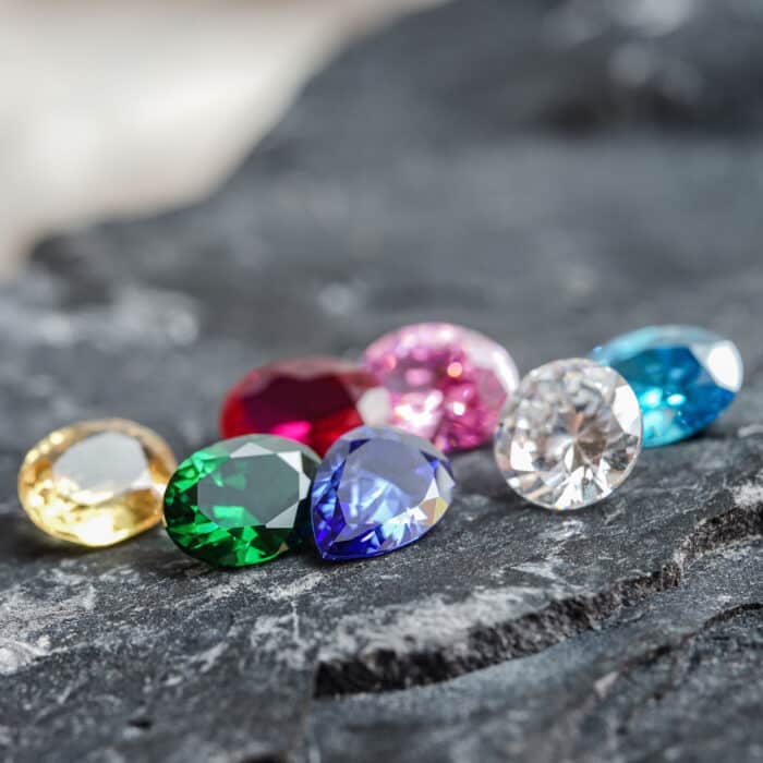 The glimmering natural colorful sapphire gemstones on a rugged rock surface