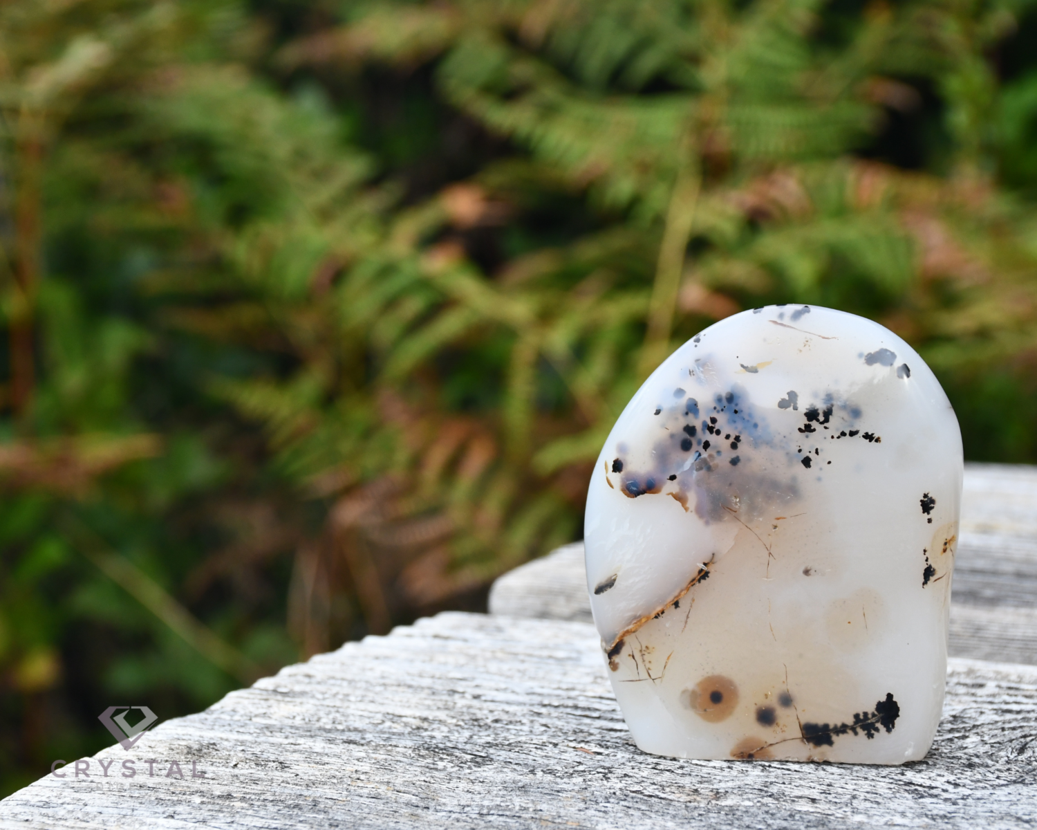 dendritic opal on a wooden table outdoors